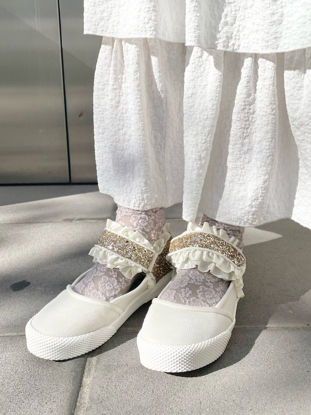 ホワイト系のスカート、ベージュ系のブルゾン、ホワイト系のニット/セーターを着用したレディースの冬コーディネートの10枚目の写真