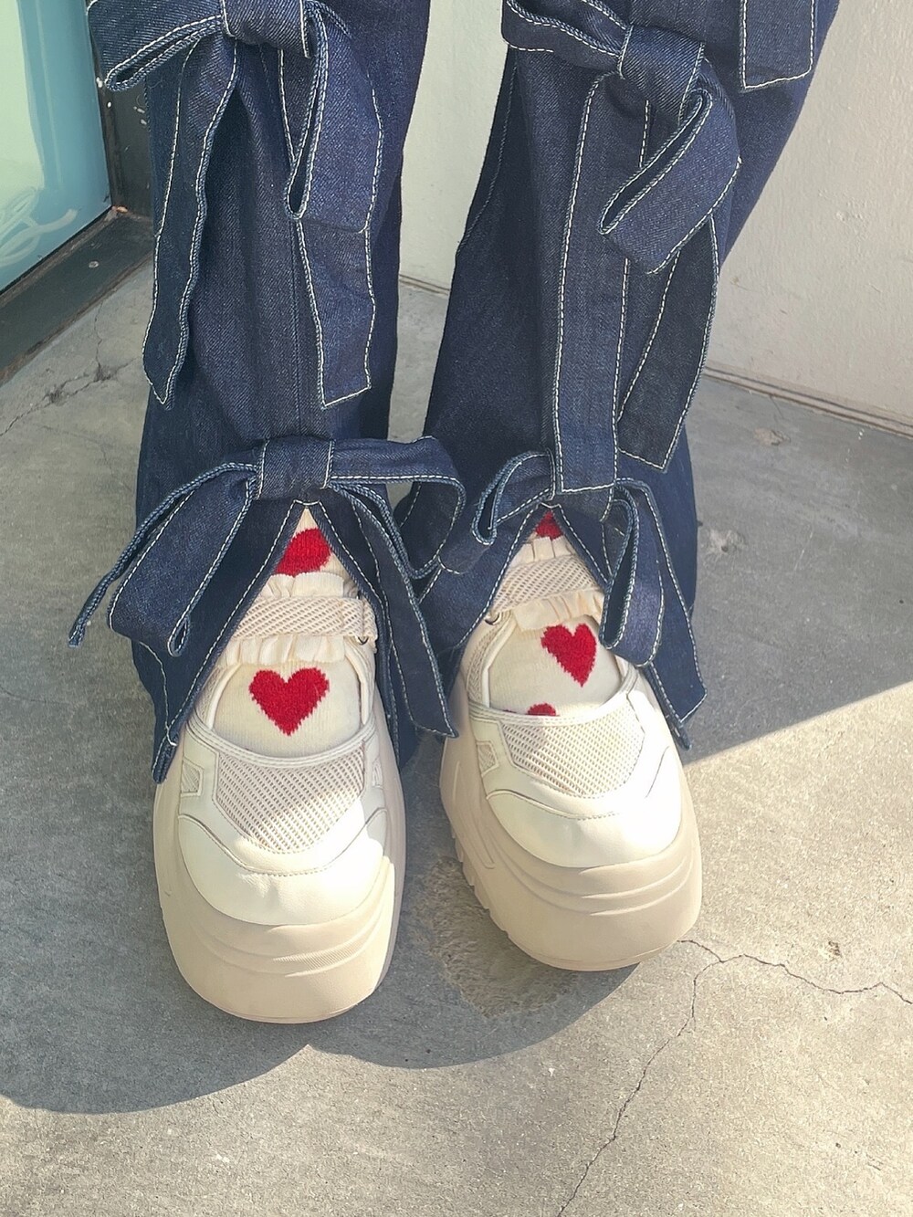 ホワイト系のダウンジャケット/コート、ブルー系のデニムパンツ、ホワイト系のスニーカーを着用したレディースの冬コーディネートの8枚目の写真