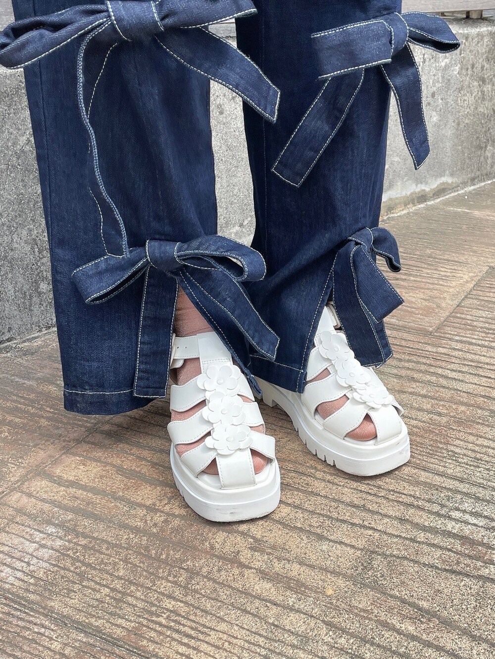 ピンク系のTシャツ/カットソー、ホワイト系のトートバッグ、ブルー系のデニムパンツを着用したレディースの春コーディネートの6枚目の写真