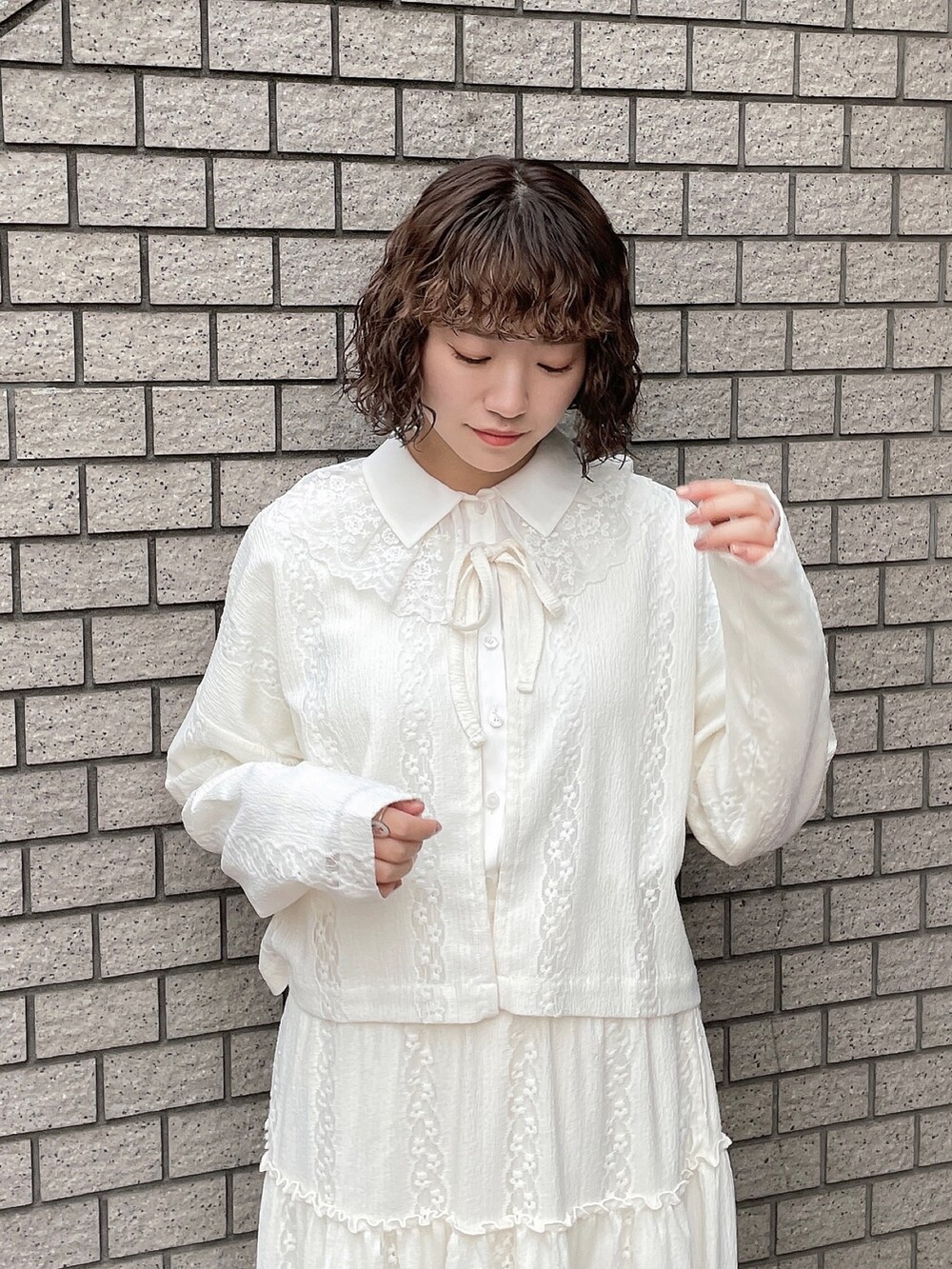 ホワイト系のスカート、ホワイト系のカーディガン/ボレロ、ホワイト系のチュニックを着用したレディースの春コーディネートの4枚目の写真