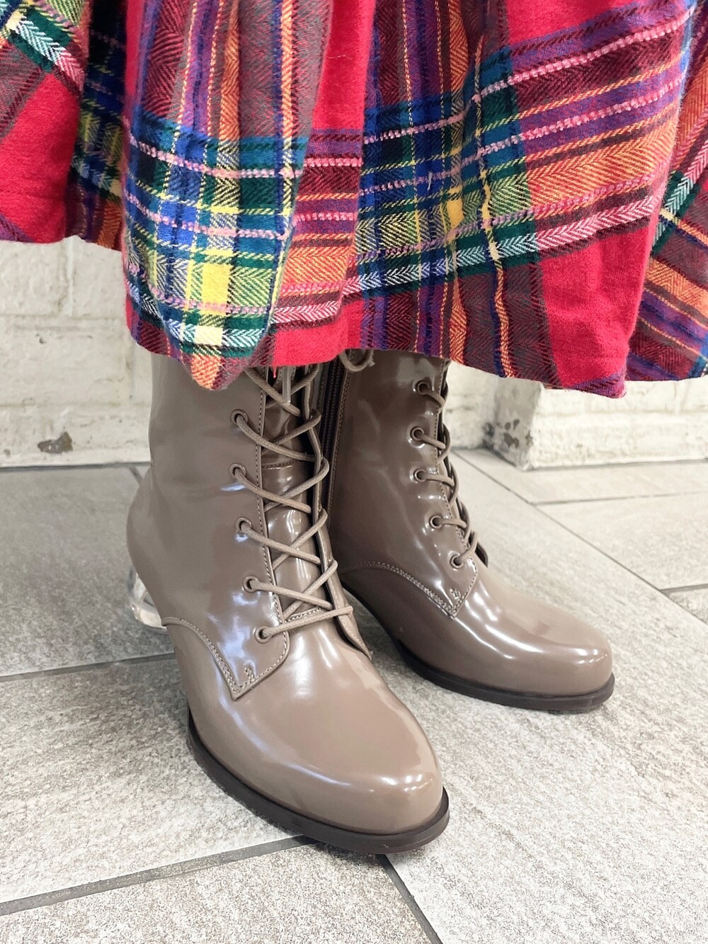 ホワイト系のニット/セーター、レッド系のスカート、ベージュ系のブーツを着用したレディースの冬コーディネートの5枚目の写真