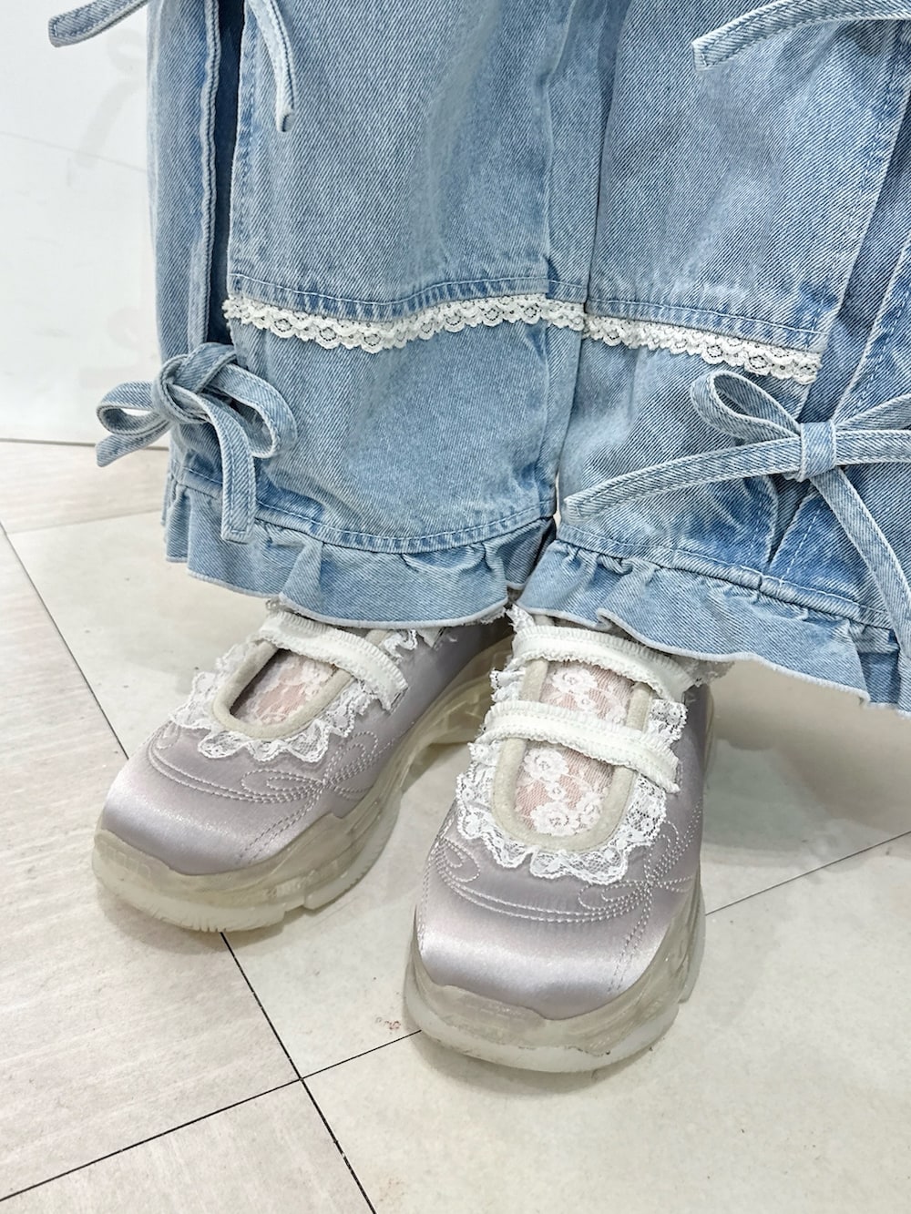 ホワイト系のブルゾン、ホワイト系のバックパック/リュック、ブルー系のデニムパンツを着用したレディースの冬コーディネートの9枚目の写真