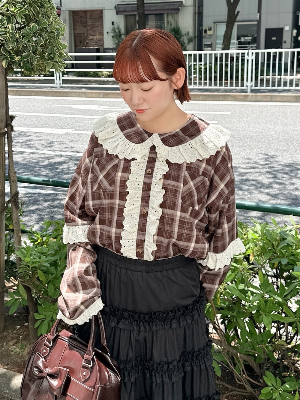 ブラウン系のハンドバッグ、ブラウン系のシャツ/ブラウス、ブラック系のスカートを着用したレディースの春コーディネートの4枚目の写真