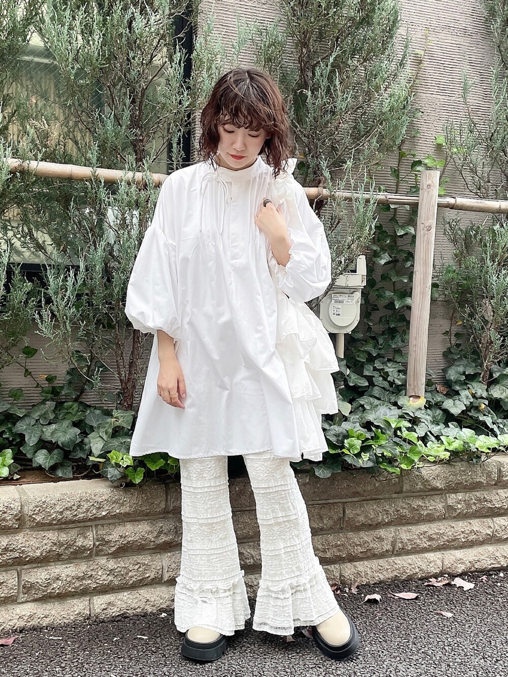 ホワイト系のワンピース、ホワイト系のスラックス、ベージュ系のブーツを着用したレディースの冬コーディネートの2枚目の写真