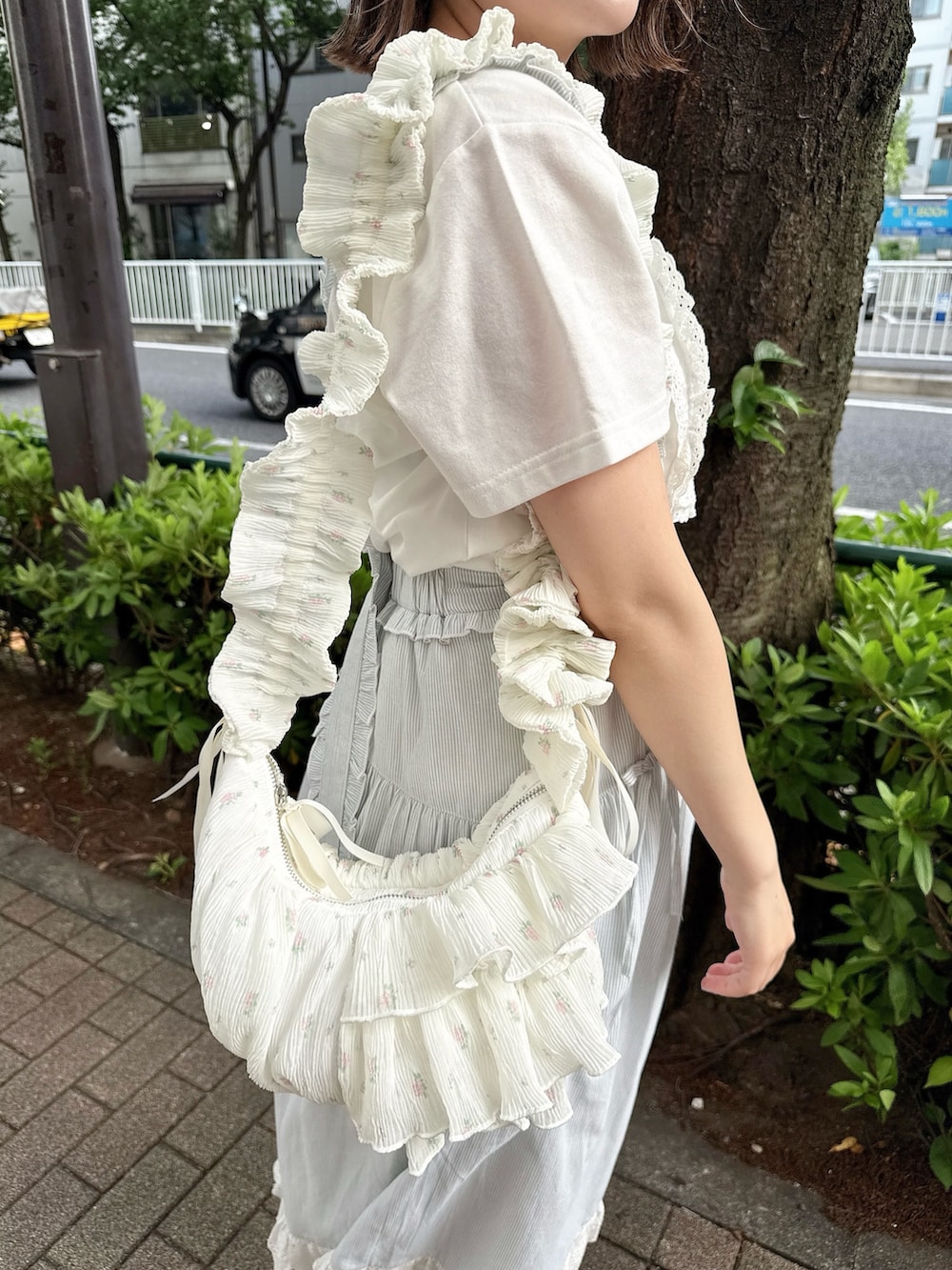ホワイト系のTシャツ/カットソー、グリーン系のジャンパースカート、ホワイト系のショルダーバッグを着用したレディースの春コーディネートの7枚目の写真