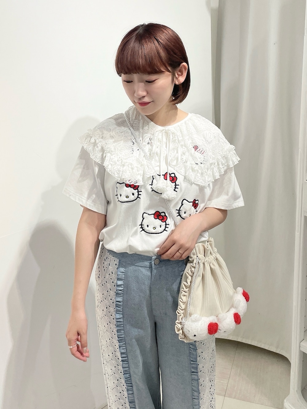 ブルー系のデニムパンツ、ホワイト系のスニーカー、ホワイト系のショルダーバッグを着用したレディースの春コーディネートの4枚目の写真