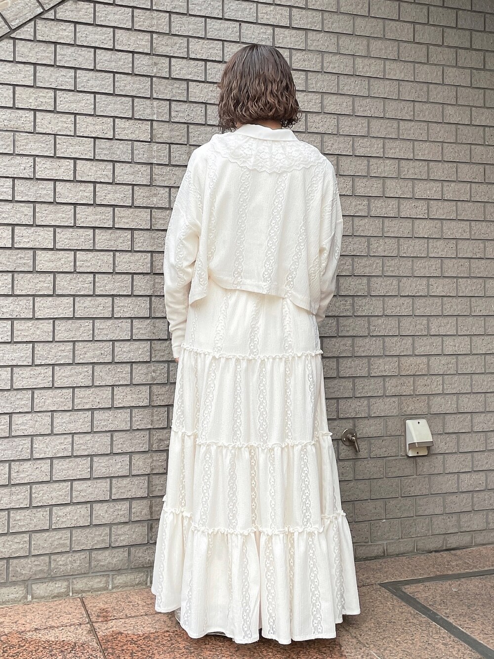 ホワイト系のスカート、ホワイト系のカーディガン/ボレロ、ホワイト系のチュニックを着用したレディースの春コーディネートの3枚目の写真