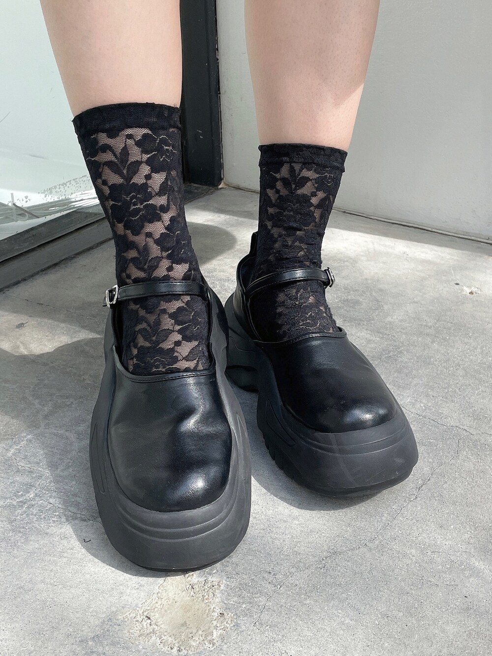 ブラック系のスニーカー、レッド系のチェスターコート、ブラック系のジャンパースカートを着用したレディースの秋コーディネートの8枚目の写真