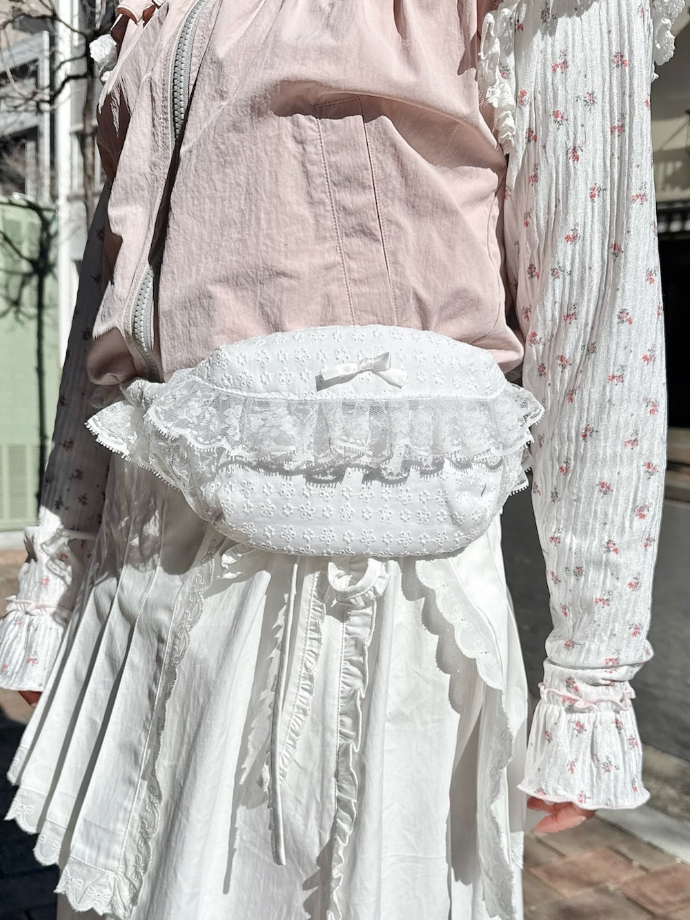 ピンク系のベスト、ピンク系のTシャツ/カットソー、ホワイト系のスカートを着用したレディースの春コーディネートの7枚目の写真