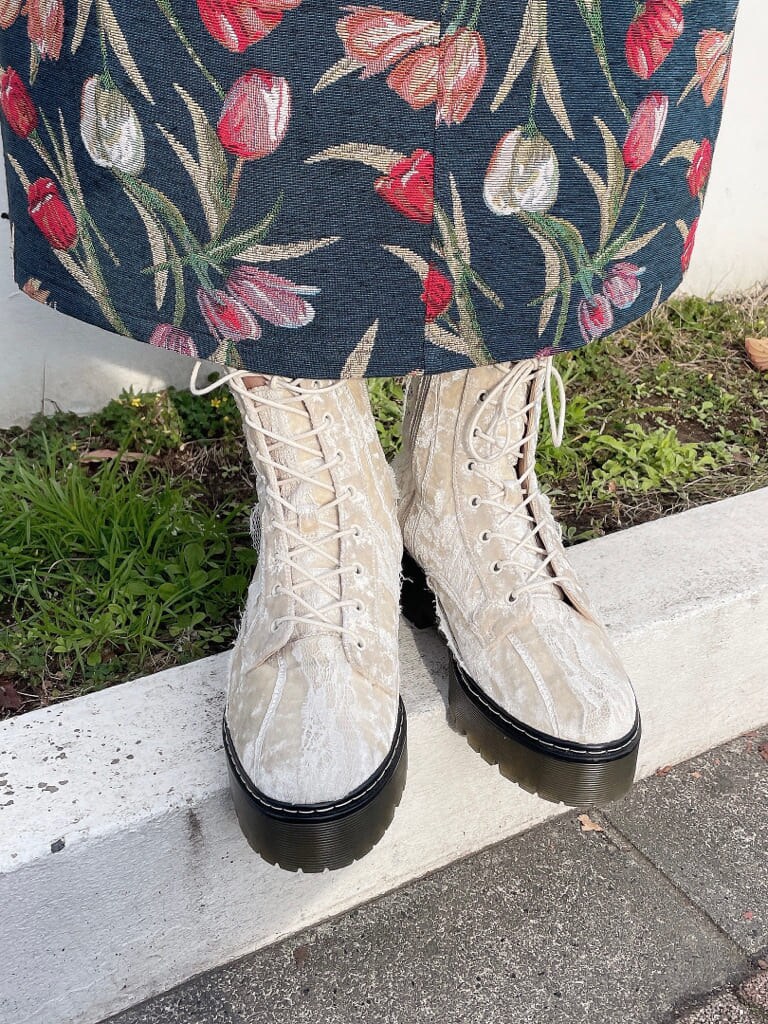 ホワイト系のブーツ、ブルー系のジャンパースカート、ホワイト系のカーディガン/ボレロを着用したレディースの冬コーディネートの6枚目の写真