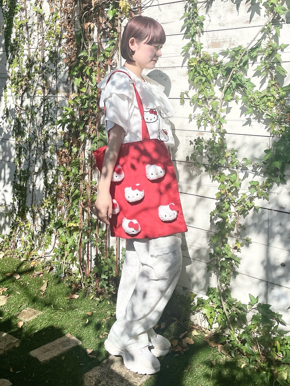 ホワイト系のスニーカー、ホワイト系のカーゴパンツ、レッド系のトートバッグを着用したレディースの春コーディネートの2枚目の写真