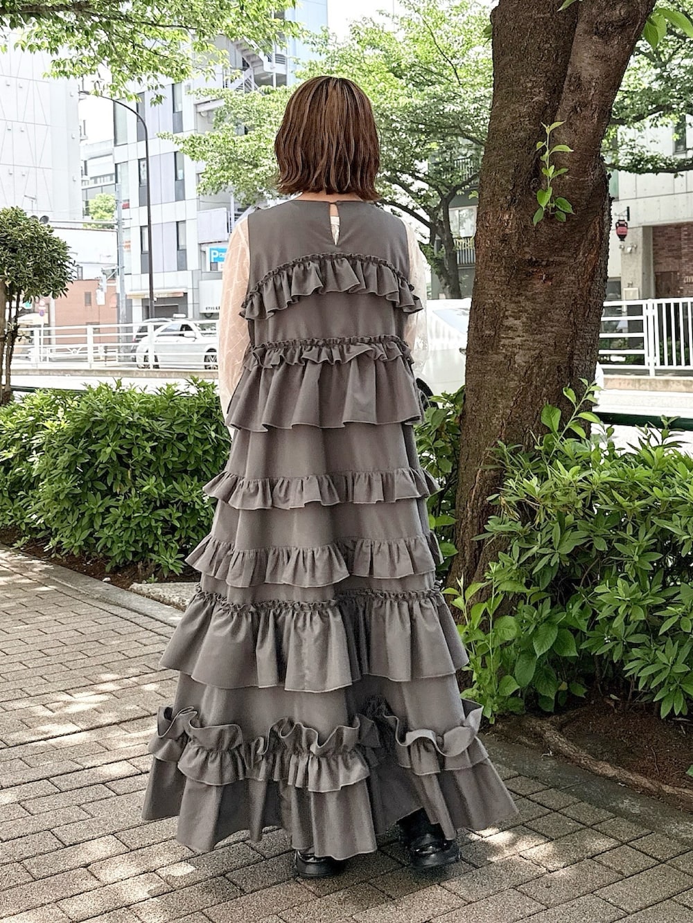 グレー系のワンピース、ホワイト系のTシャツ/カットソー、ホワイト系のボストンバッグを着用したレディースの春コーディネートの3枚目の写真