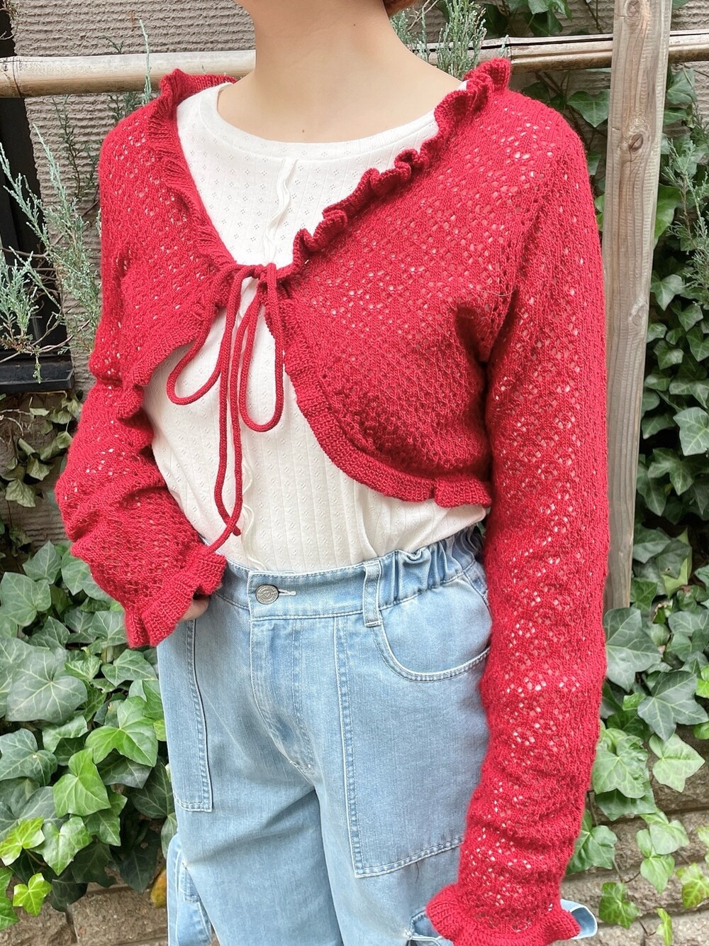 ブルー系のデニムパンツ、レッド系のカーディガン/ボレロ、ホワイト系のTシャツ/カットソーを着用したレディースの冬コーディネートの5枚目の写真