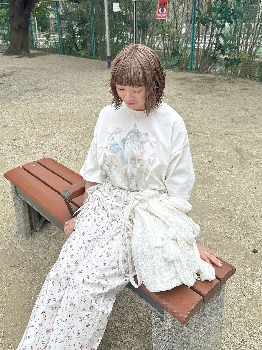 ホワイト系のTシャツ/カットソー、ホワイト系のスラックス、ホワイト系のトートバッグを着用したレディースの春コーディネートの2枚目の写真