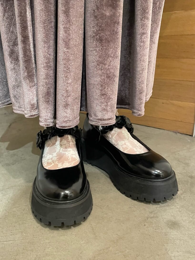 パープル系のスカート、ブラック系のローファー、レッド系のニット/セーターを着用したレディースの秋コーディネートの5枚目の写真