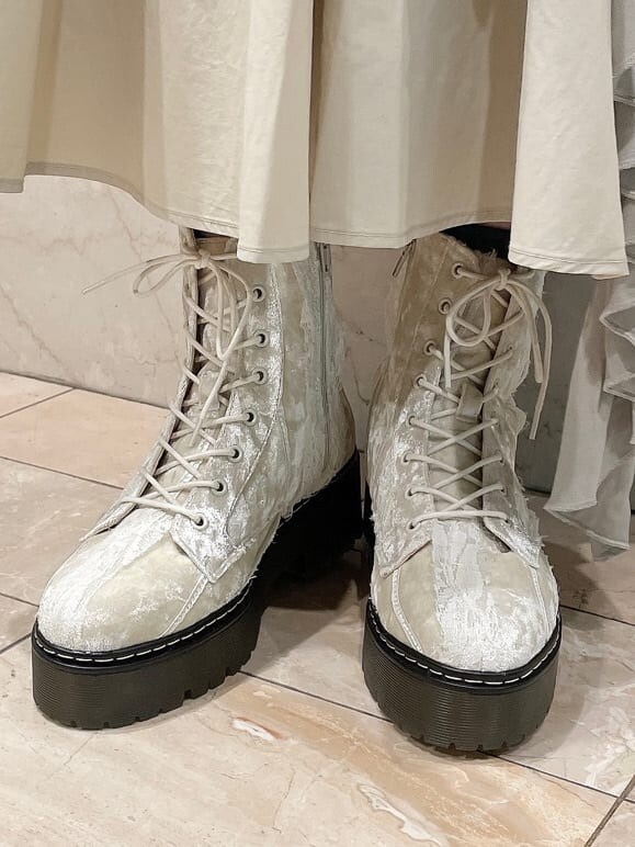 ホワイト系のニット/セーター、ベージュ系のスカート、ホワイト系のブーツを着用したレディースの秋コーディネートの6枚目の写真