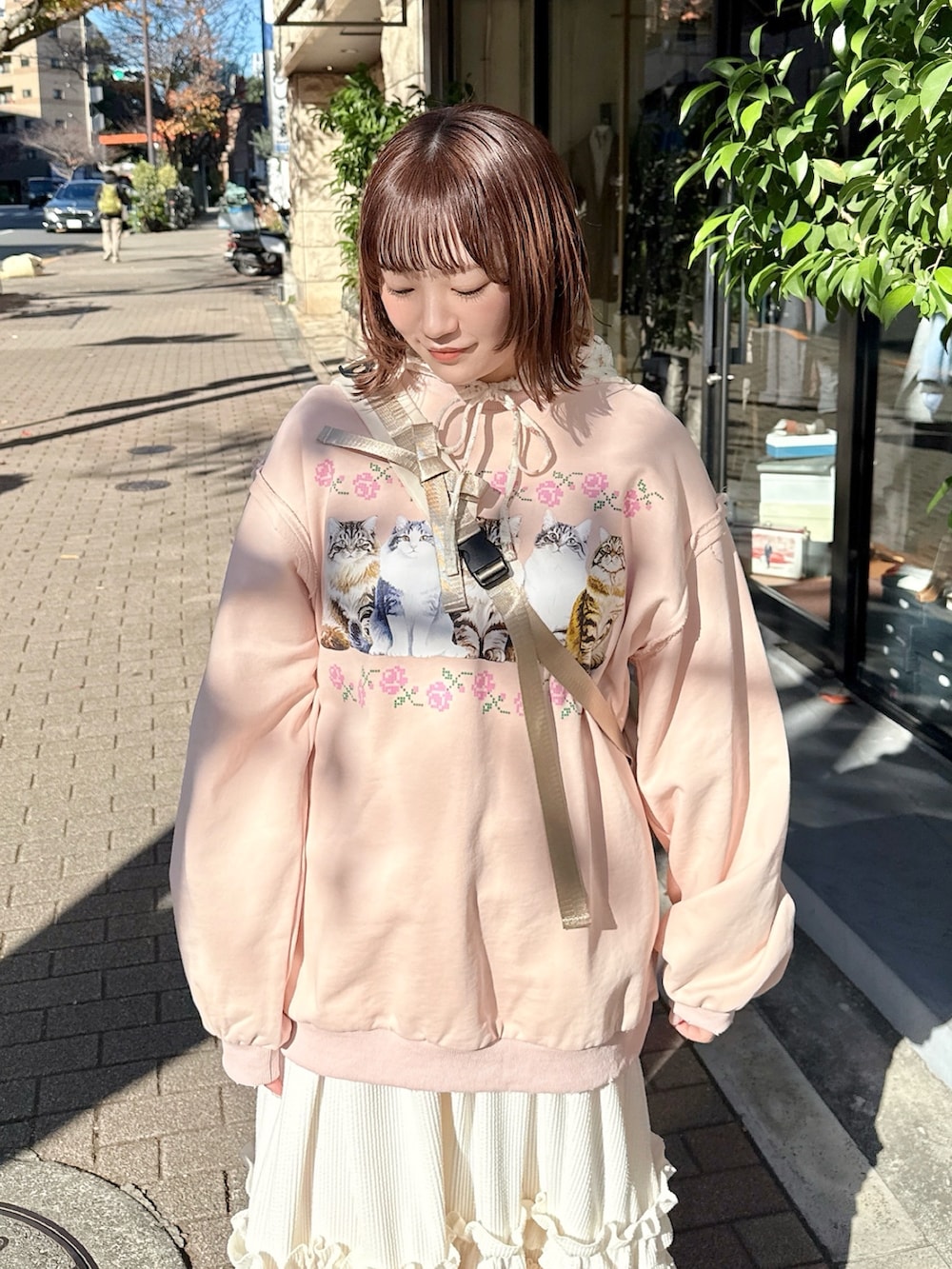 ピンク系のスウェット、ホワイト系のTシャツ/カットソー、ホワイト系のスカートを着用したレディースの冬コーディネートの3枚目の写真