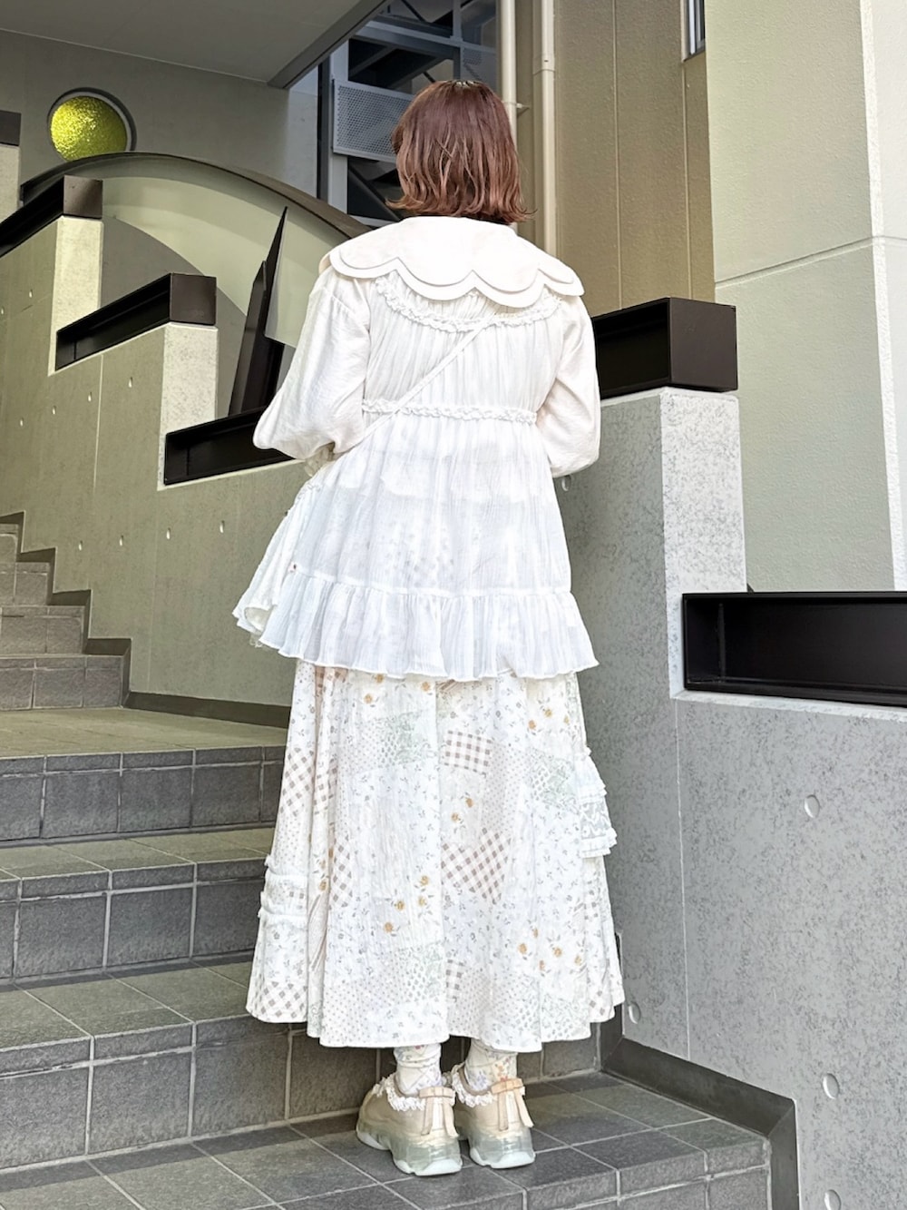 ピンク系のシャツ/ブラウス、ホワイト系のスカート、ホワイト系のショルダーバッグを着用したレディースの春コーディネートの3枚目の写真