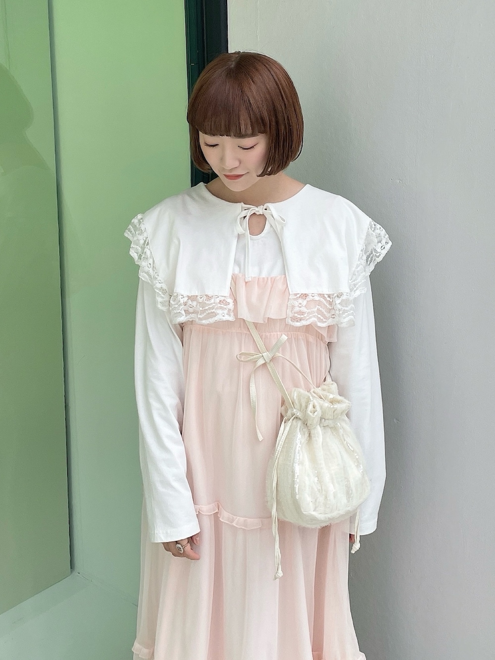 ホワイト系のTシャツ/カットソー、ホワイト系のショルダーバッグ、ピンク系のワンピースを着用したレディースの冬コーディネートの4枚目の写真