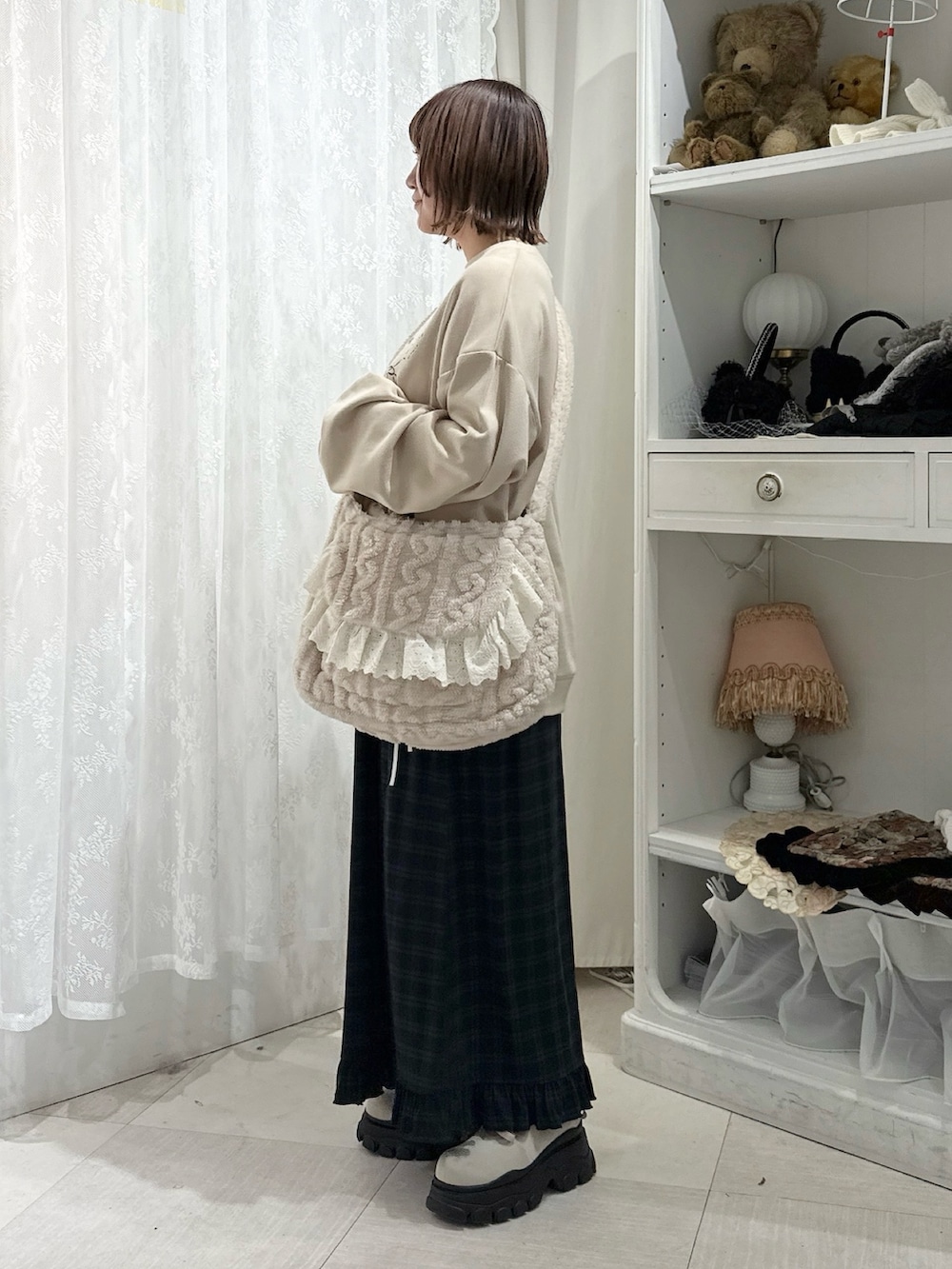 ベージュ系のスウェット、ベージュ系のショルダーバッグ、グリーン系のスカートを着用したレディースの秋コーディネートの3枚目の写真