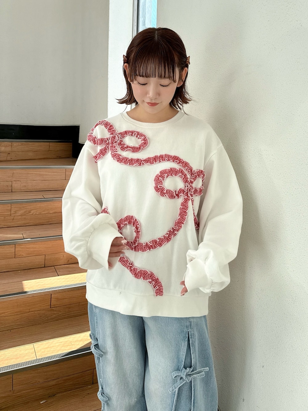 ホワイト系のブルゾン、ホワイト系のスウェット、ブルー系のデニムパンツを着用したレディースの冬コーディネートの7枚目の写真