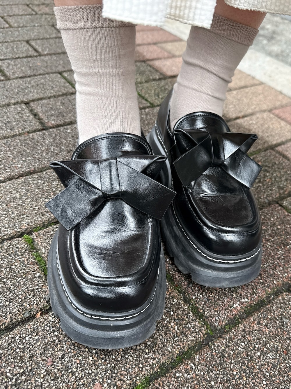 ホワイト系のスカート、グレー系のニット/セーター、ホワイト系のバックパック/リュックを着用したレディースの秋コーディネートの8枚目の写真