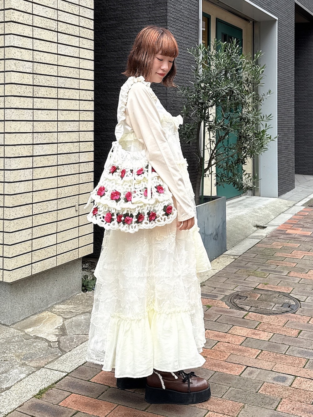 ベージュ系のTシャツ/カットソー、ホワイト系のワンピース、ホワイト系のスカートを着用したレディースの夏コーディネートの3枚目の写真