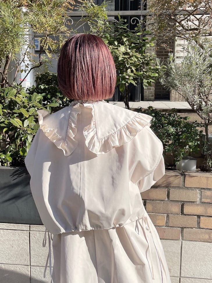 ホワイト系のトレンチコート、オレンジ系のシャツ/ブラウス、ブルー系のスカートを着用したレディースの冬コーディネートの5枚目の写真