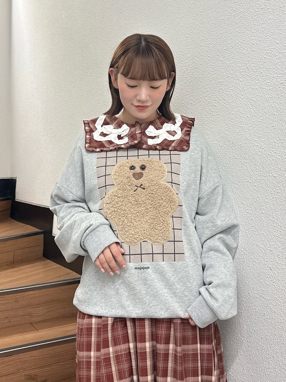 グレー系のスウェット、レッド系のワンピース、ブラウン系のハンドバッグを着用したレディースの秋コーディネートの5枚目の写真