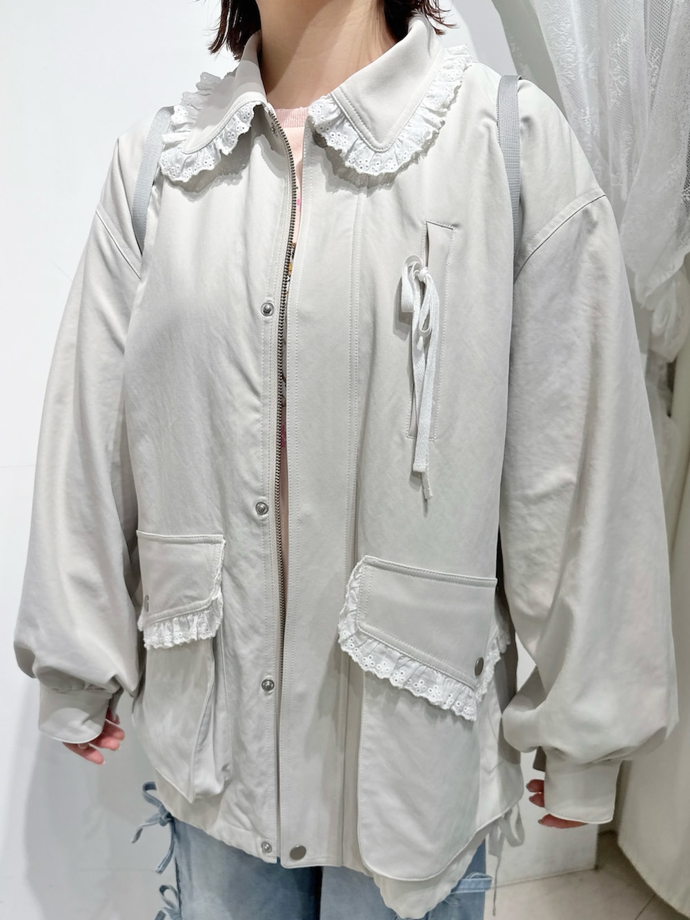 ホワイト系のブルゾン、ホワイト系のバックパック/リュック、ブルー系のデニムパンツを着用したレディースの冬コーディネートの8枚目の写真