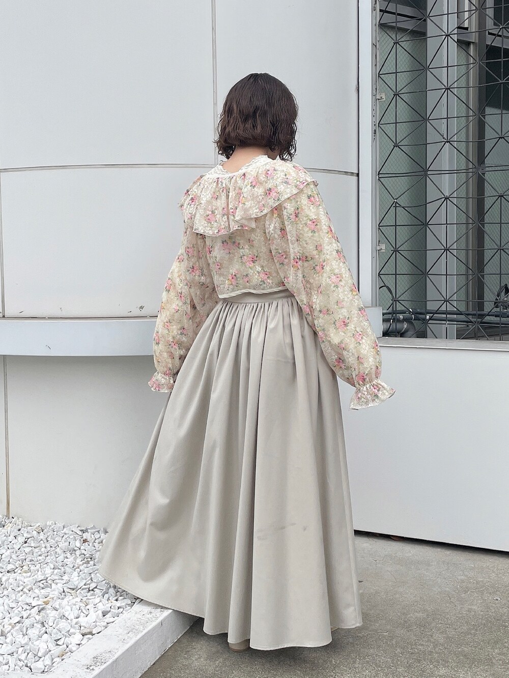 ホワイト系のカーディガン/ボレロ、ホワイト系のTシャツ/カットソー、ベージュ系のスカートを着用したレディースの冬コーディネートの4枚目の写真