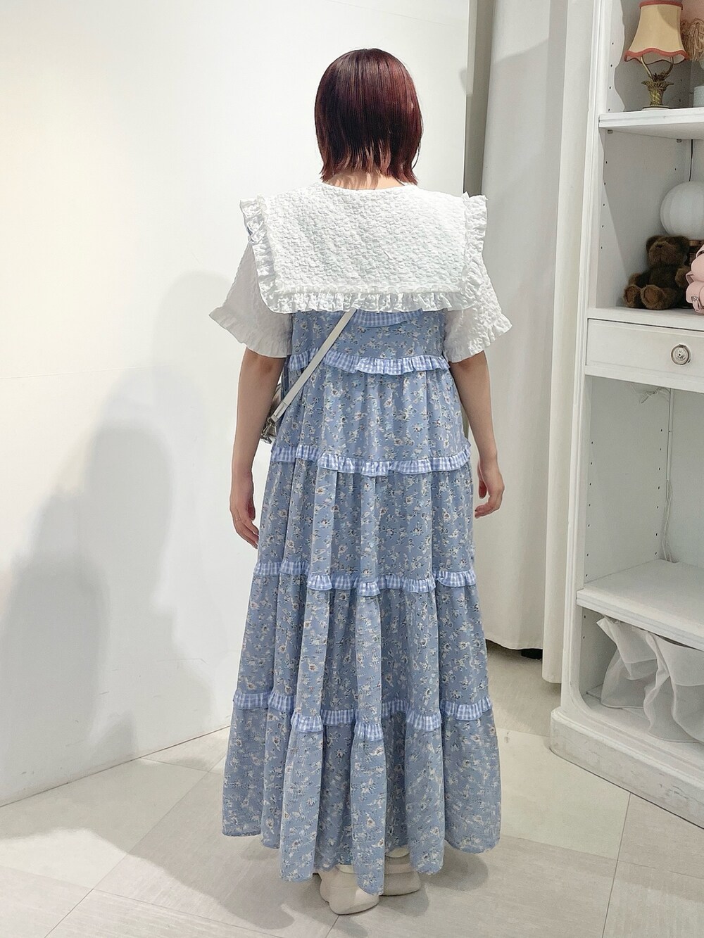 シルバー系のショルダーバッグ、ブルー系のワンピース、ホワイト系のシャツ/ブラウスを着用したレディースの夏コーディネートの3枚目の写真