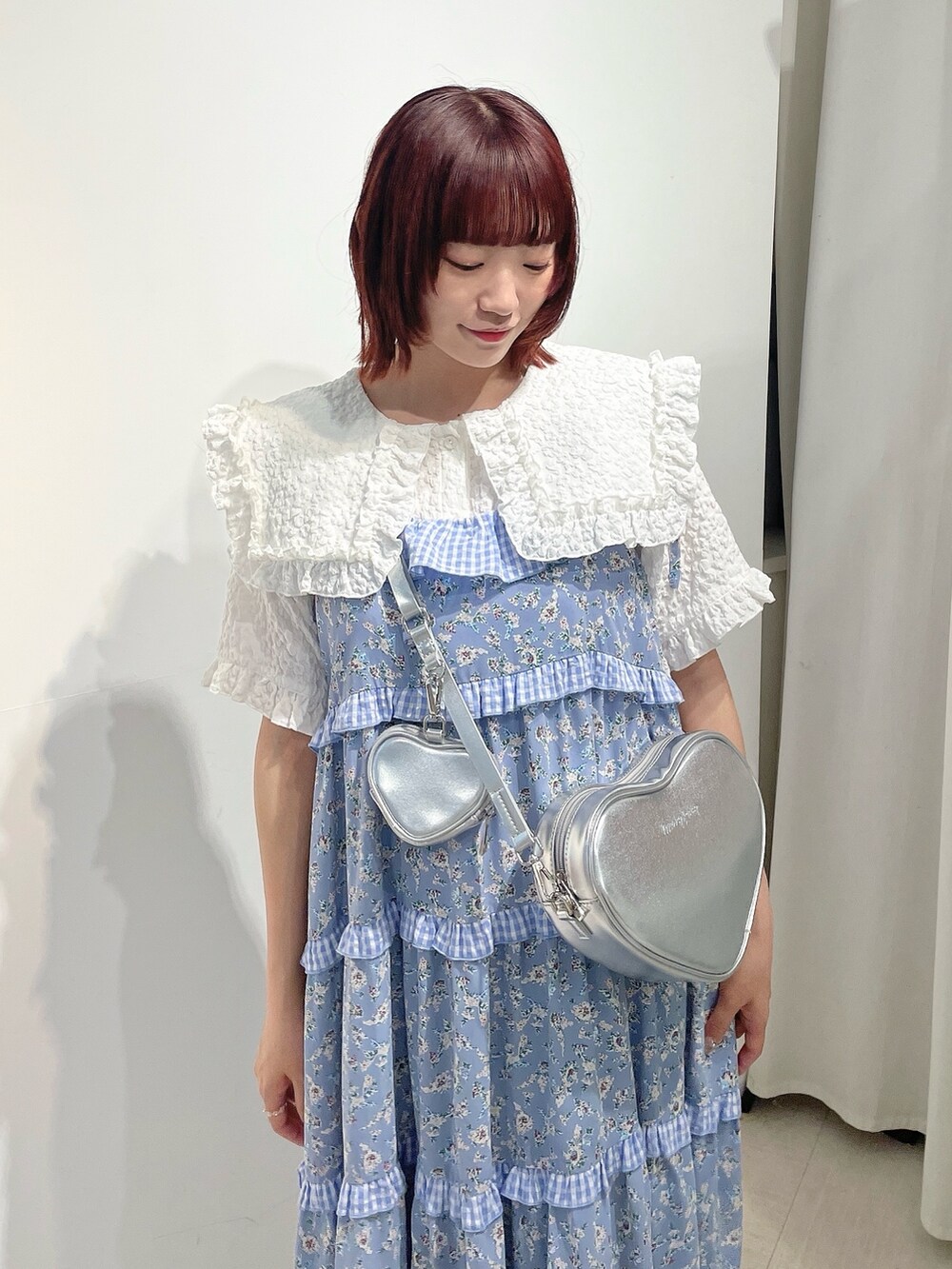 シルバー系のショルダーバッグ、ブルー系のワンピース、ホワイト系のシャツ/ブラウスを着用したレディースの夏コーディネートの4枚目の写真
