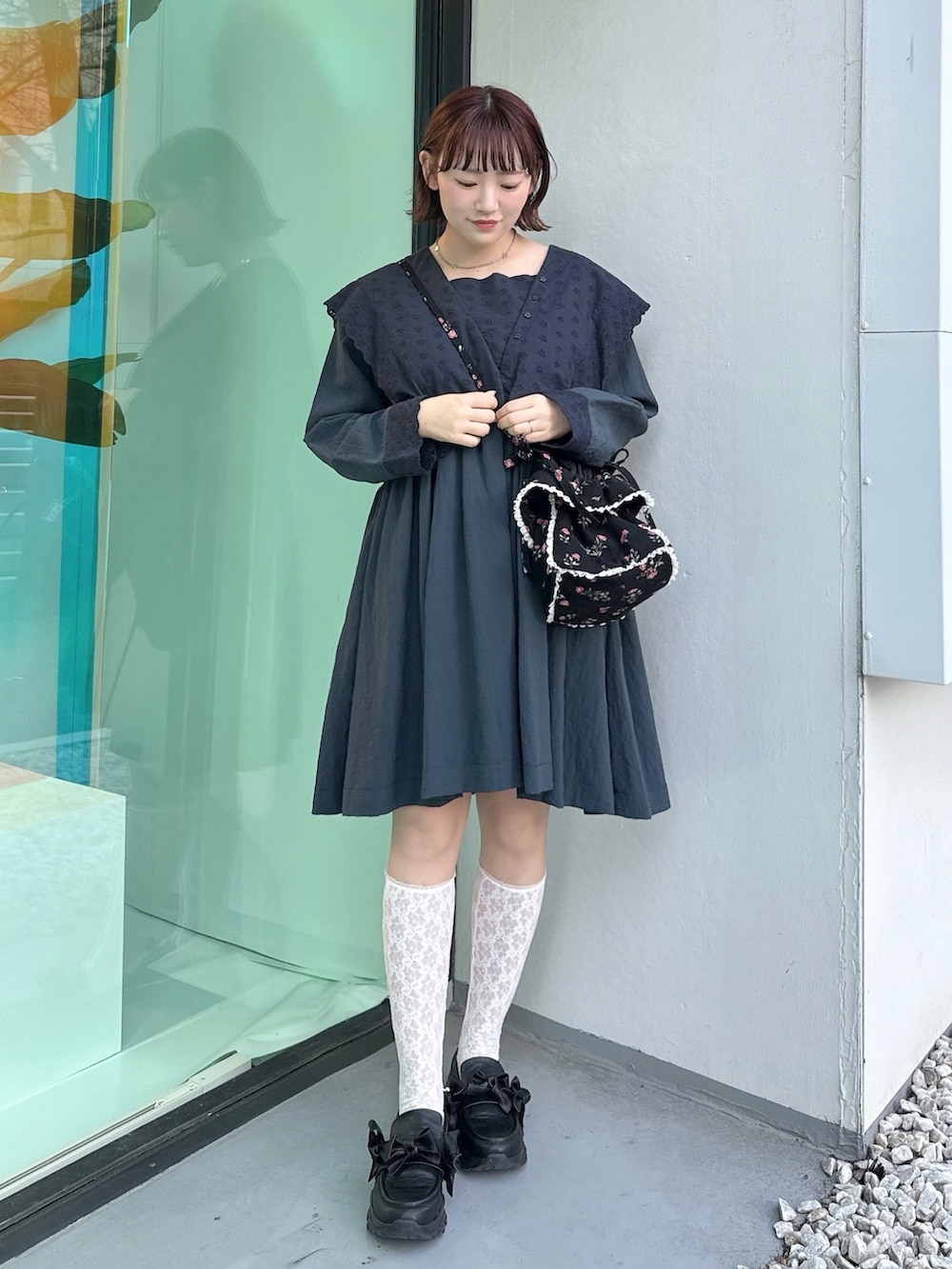 ブルー系のワンピース、ブラック系のショルダーバッグ、ブラック系のスニーカーを着用したレディースの冬コーディネートの2枚目の写真