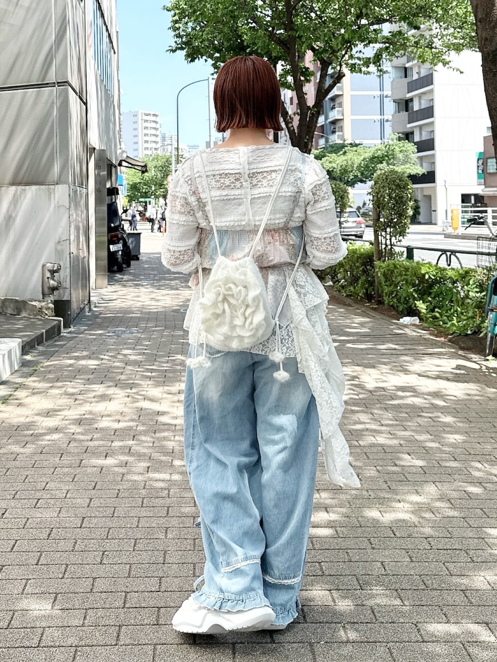 ホワイト系のTシャツ/カットソー、ピンク系のキャミソール、ブルー系のデニムパンツを着用したレディースの春コーディネートの3枚目の写真