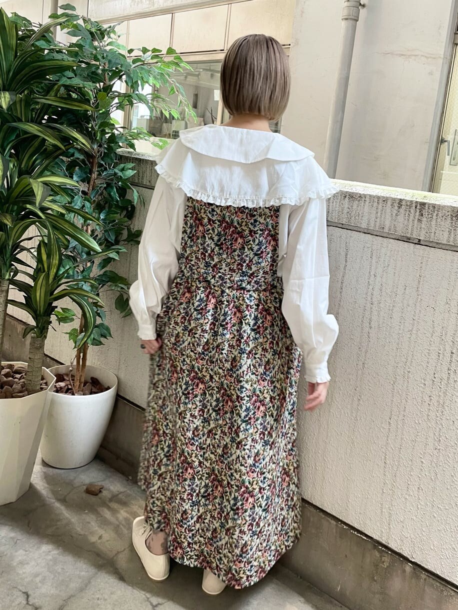 レッド系のスカート、ホワイト系のその他シューズ、ホワイト系のシャツ/ブラウスを着用したレディースの夏コーディネートの3枚目の写真