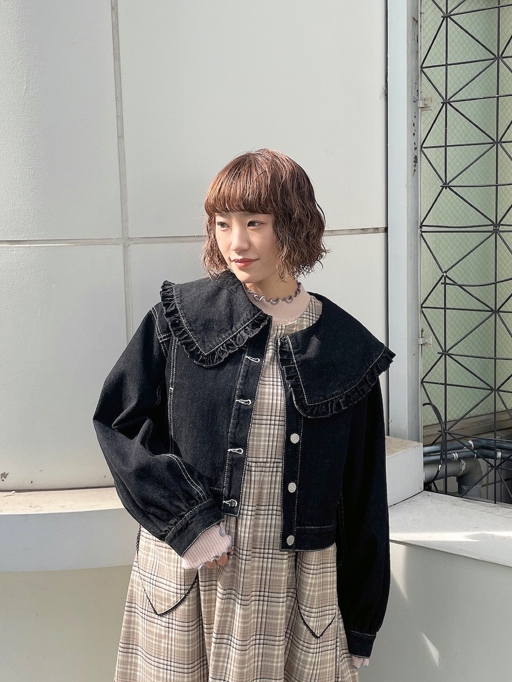 ピンク系のニット/セーター、ブラック系のデニムジャケット、ベージュ系のワンピースを着用したレディースの夏コーディネートの3枚目の写真