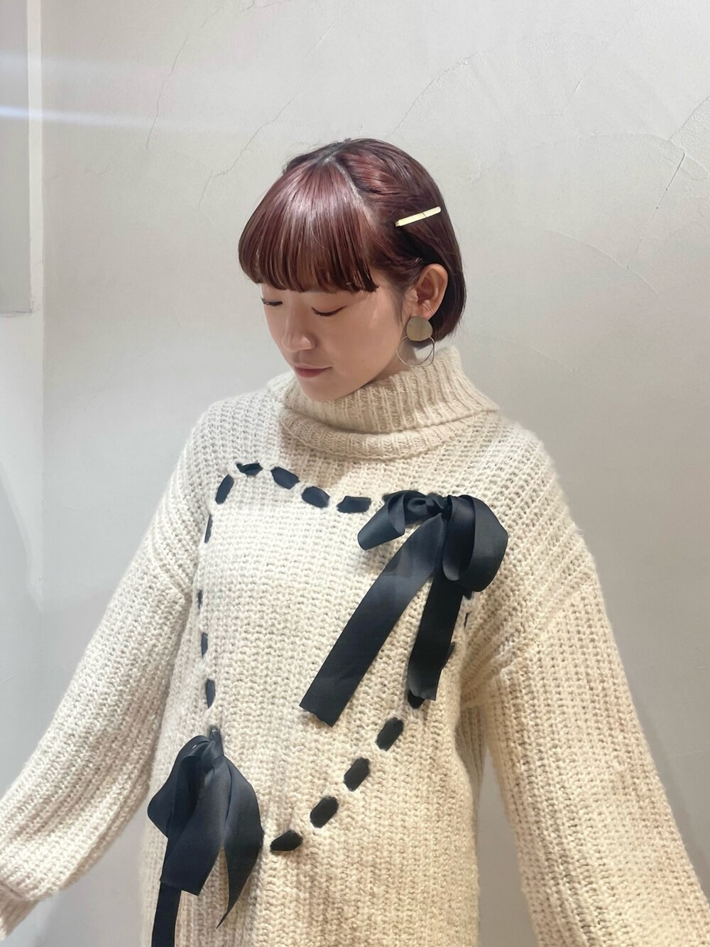 ホワイト系のニット/セーター、ブラウン系のパンプス、ホワイト系のスカートを着用したレディースの冬コーディネートの4枚目の写真