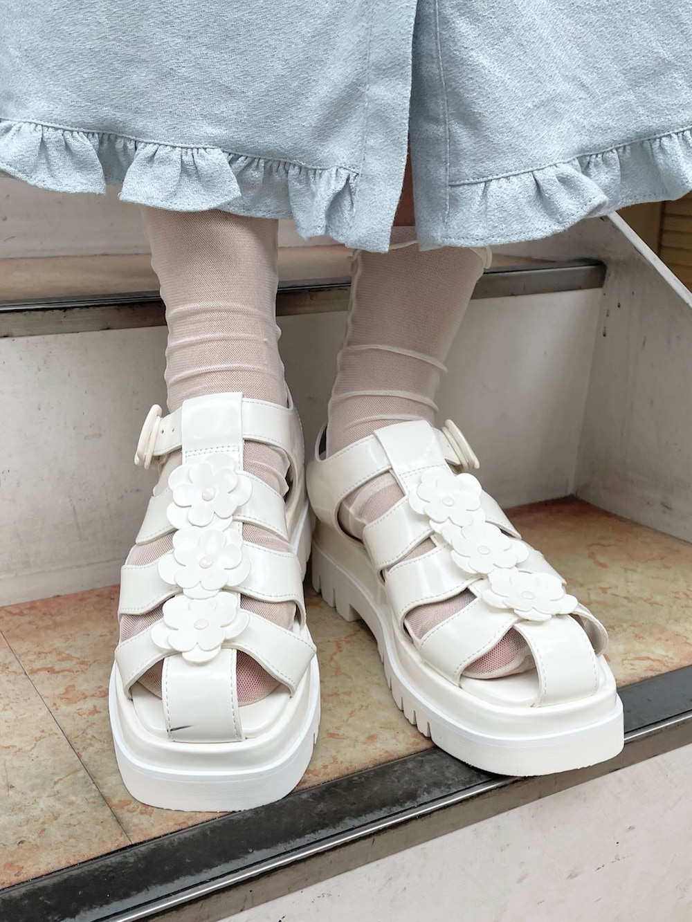 ホワイト系のベスト、ブルー系のワンピース、ホワイト系のサンダルを着用したレディースの夏コーディネートの5枚目の写真