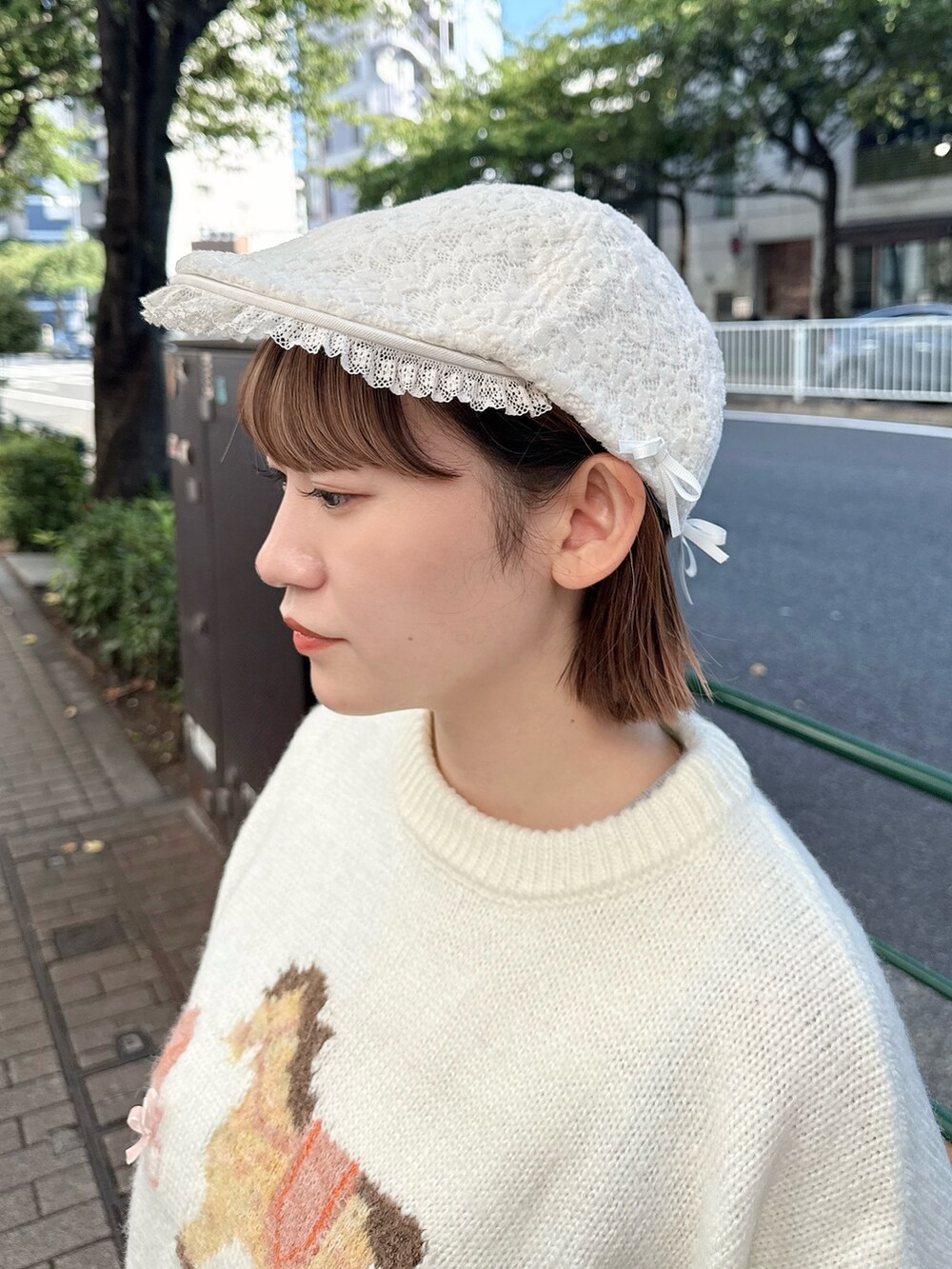 ホワイト系のニット/セーター、ホワイト系のショルダーバッグ、レッド系のスカートを着用したレディースの秋コーディネートの7枚目の写真