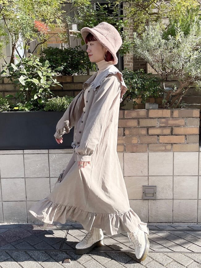 ホワイト系のニット/セーター、ベージュ系のスカート、ホワイト系のブーツを着用したレディースの冬コーディネートの3枚目の写真