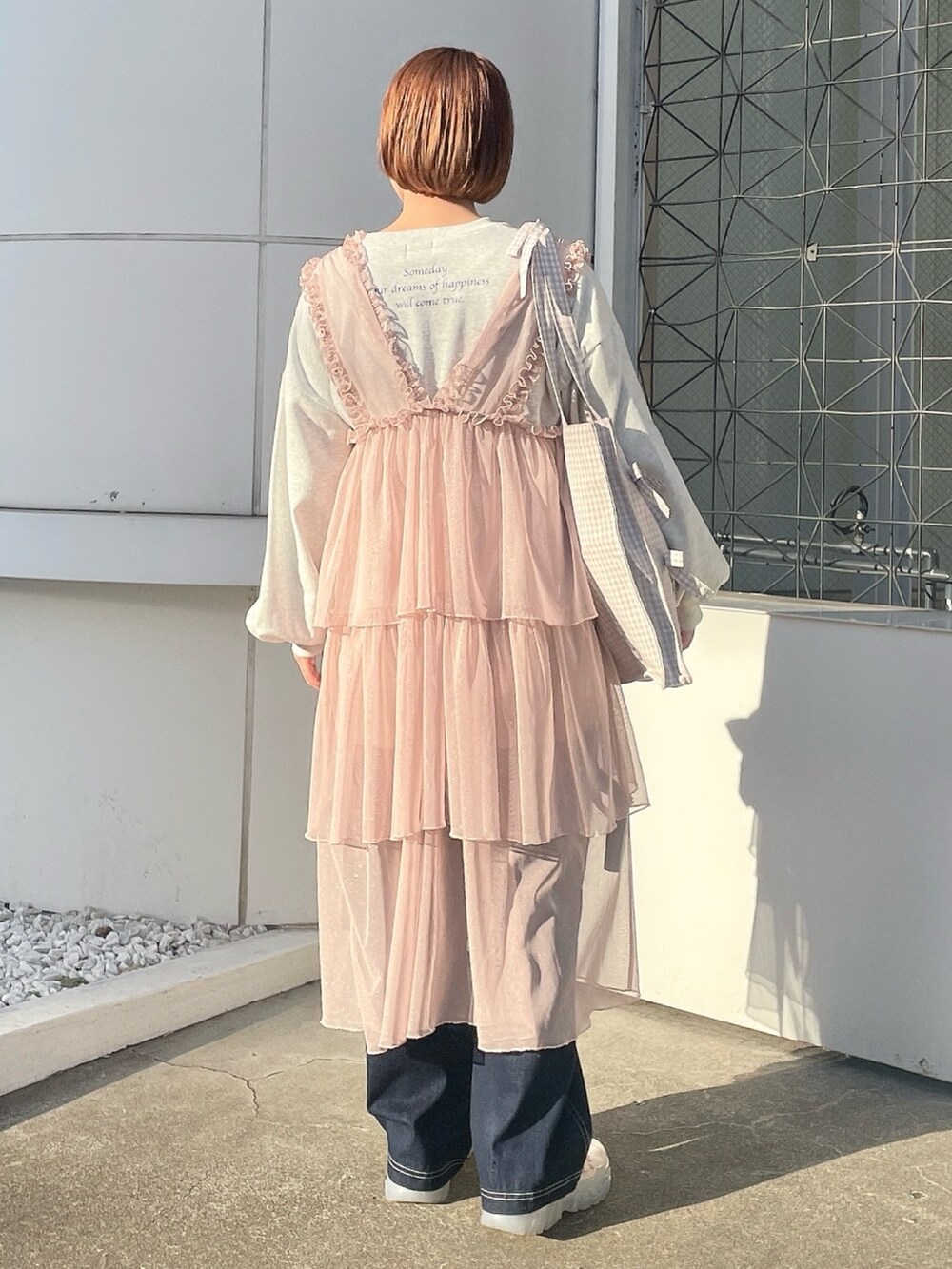 ベージュ系のトートバッグ、グレー系のスウェット、ピンク系のワンピースを着用したレディースの春コーディネートの4枚目の写真