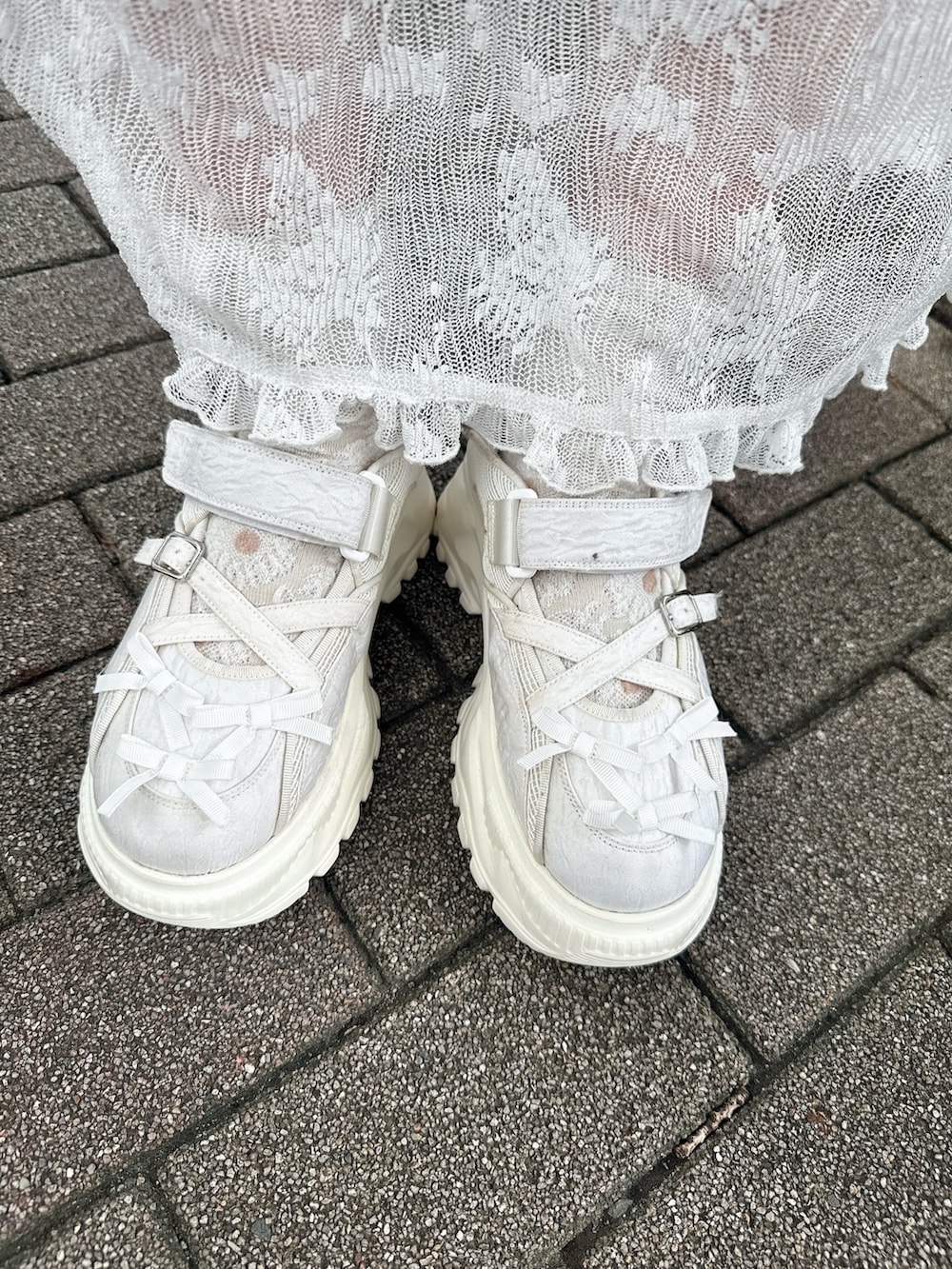 ピンク系のニット/セーター、ホワイト系のショルダーバッグ、ホワイト系のワンピースを着用したレディースの夏コーディネートの5枚目の写真