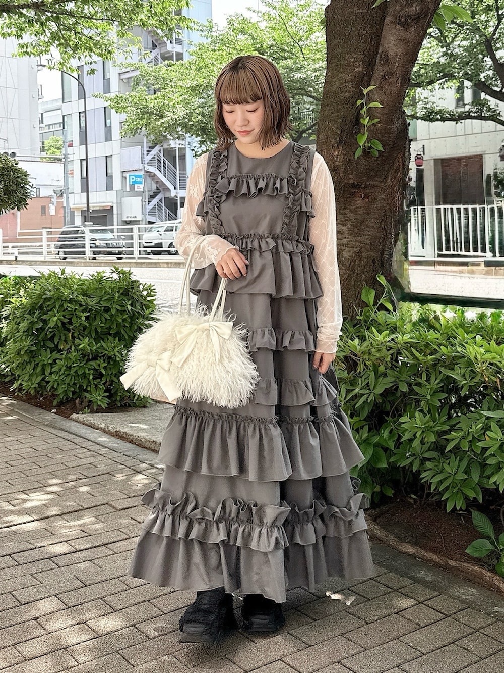 グレー系のワンピース、ホワイト系のTシャツ/カットソー、ホワイト系のボストンバッグを着用したレディースの春コーディネートの2枚目の写真
