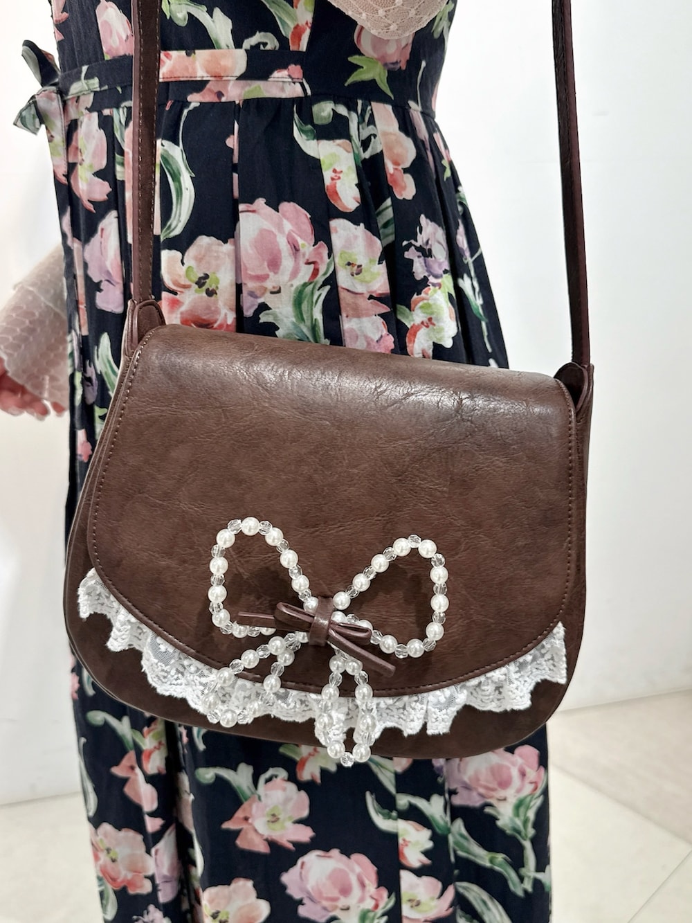 ホワイト系のTシャツ/カットソー、ブラック系のワンピース、ブラウン系のショルダーバッグを着用したレディースの春コーディネートの6枚目の写真