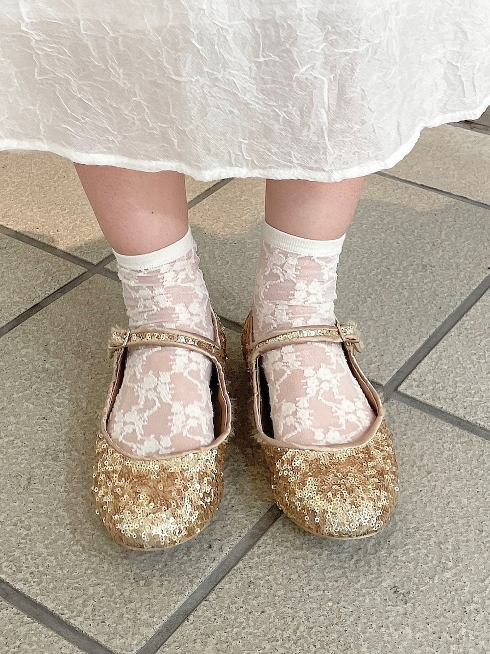 ホワイト系のワンピース、ピンク系のシャツ/ブラウス、ゴールド系のパンプスを着用したレディースの春コーディネートの6枚目の写真