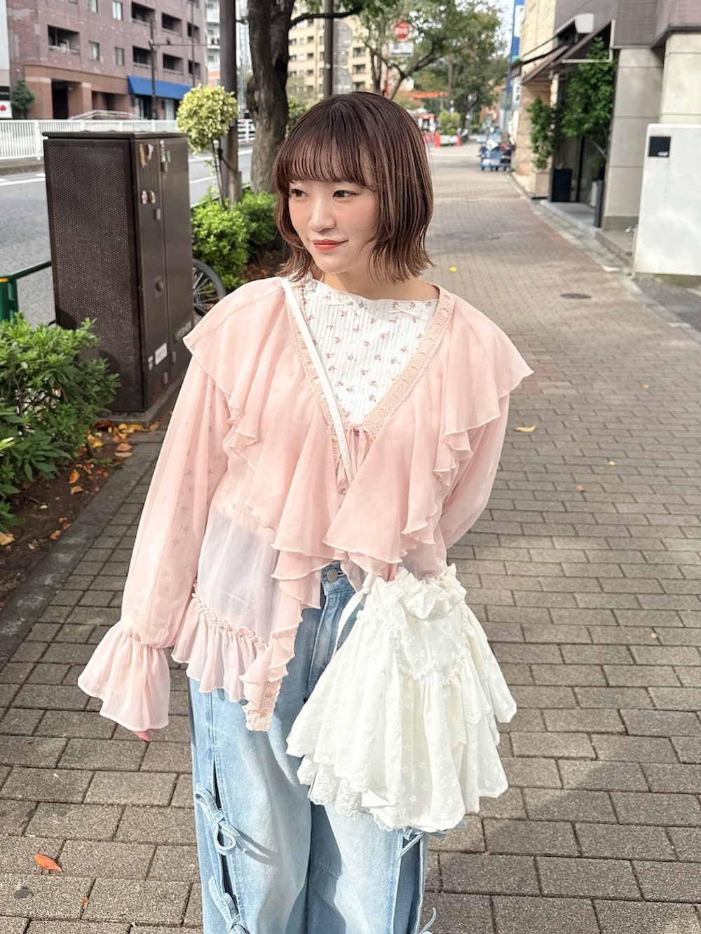 ピンク系のカーディガン/ボレロ、ピンク系のTシャツ/カットソー、ホワイト系のショルダーバッグを着用したレディースの秋コーディネートの5枚目の写真