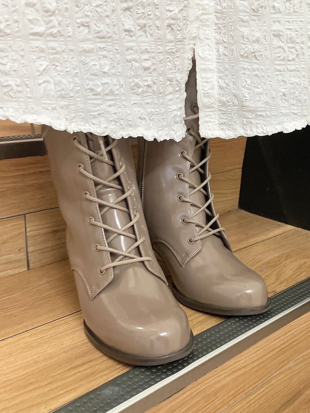 ホワイト系のワンピース、ベージュ系のブーツを着用したレディースの秋コーディネートの6枚目の写真