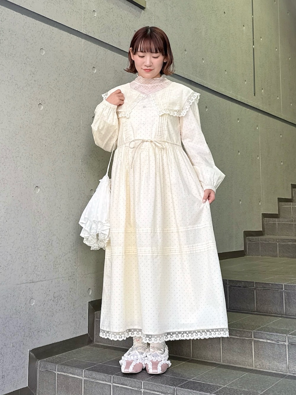 ベージュ系のワンピース、ピンク系のTシャツ/カットソー、ホワイト系のショルダーバッグを着用したレディースの春コーディネートの2枚目の写真