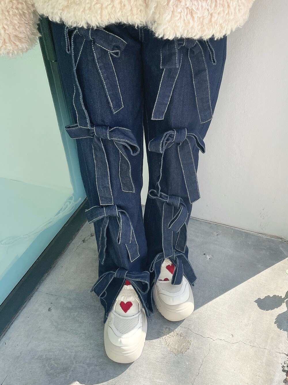 ホワイト系のダウンジャケット/コート、ブルー系のデニムパンツ、ホワイト系のスニーカーを着用したレディースの冬コーディネートの7枚目の写真